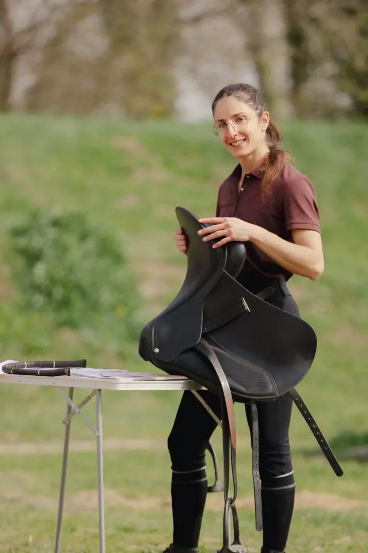 Camille Tao Bordaberry, enseignante d'équitation spécialisée en dressage, locomotion et biomécanique, et saddle fitter certifiée par Ergonomie Équestre, tenant une selle de dressage Wintec.